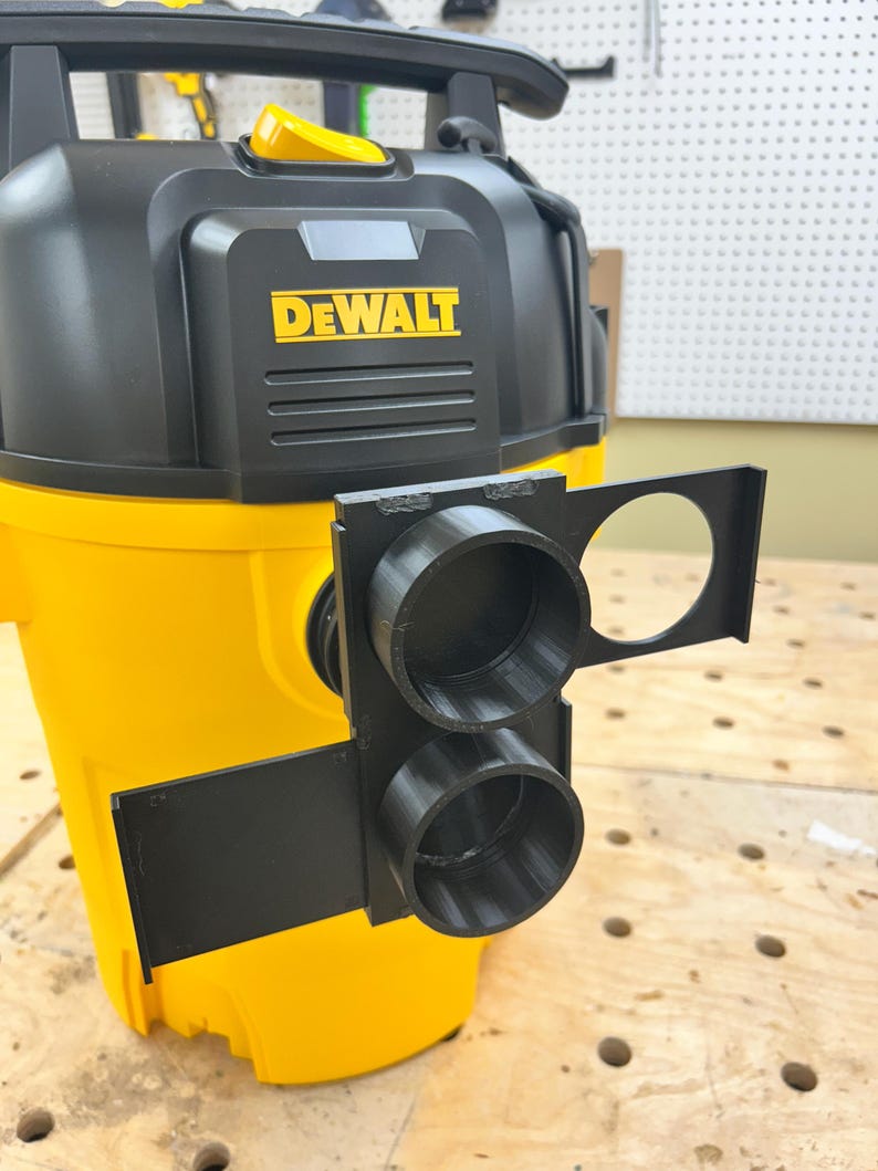 May include: A yellow and black DEWALT wet/dry vacuum with a black 3D-printed attachment. The attachment has two circular openings and a larger circular opening. The DEWALT logo is in yellow.