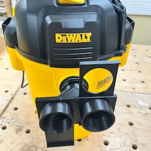 May include: A yellow and black DEWALT wet/dry vacuum with a black attachment. The vacuum has a yellow handle and the DEWALT logo in yellow. The attachment has two circular openings.