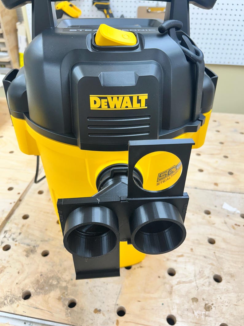 May include: A yellow and black DEWALT wet/dry vacuum with a black attachment. The vacuum has a yellow handle and the DEWALT logo in yellow. The attachment has two circular openings.