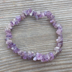 May include: A purple amethyst chip bracelet made of small, irregular shaped stones.
