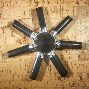 Peut inclure: Pointes de cristal d'obsidienne noire disposées en étoile sur un fond de liège. Les pointes sont polies et ont des accents argentés.