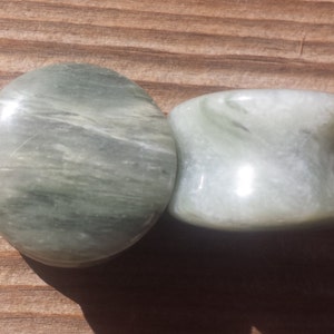 May include: Two green and white marble stone ear gauges. The gauges are round and have a swirling pattern.