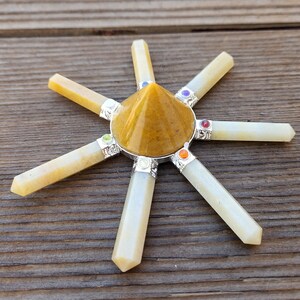 May include: A yellow crystal pyramid with seven white crystal points radiating outward. Each point has a small colored gemstone at the end.