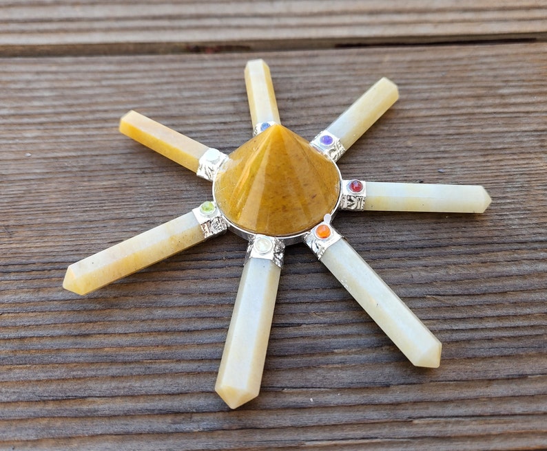 May include: A yellow crystal pyramid with seven white crystal points radiating outward. Each point has a small colored gemstone at the end.