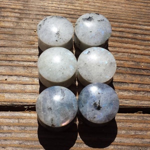 May include: Six round, white and blue gemstone plugs. The plugs are made of natural stone and have a speckled appearance.