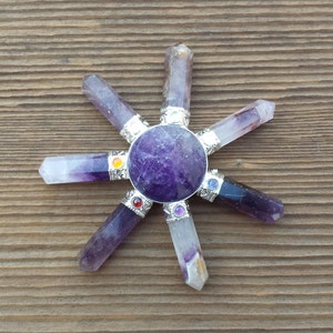 May include: A purple amethyst crystal chakra spinning wheel with seven chakra stones. The chakra stones are red, orange, yellow, green, blue, indigo, and violet.