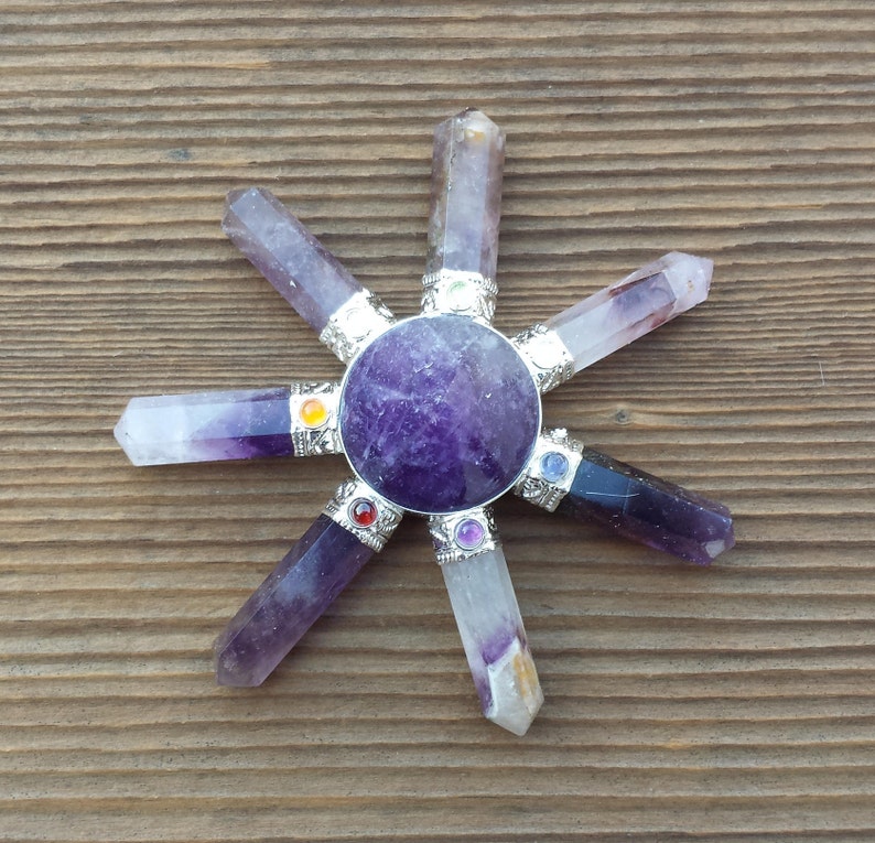 May include: A purple amethyst crystal chakra spinning wheel with seven chakra stones. The chakra stones are red, orange, yellow, green, blue, indigo, and violet.