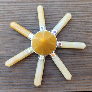 May include: A yellow crystal chakra set with seven chakra stones. The set includes a yellow crystal pyramid and six yellow crystal points.