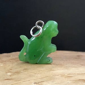 May include: A small green jade monkey charm with a silver loop for hanging.