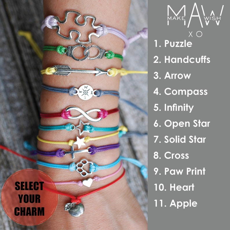 May include: A close-up of a person's wrist wearing eleven colorful bracelets with different charms, including a puzzle, handcuffs, arrow, compass, infinity symbol, open star, solid star, cross, paw print, heart, and apple. The bracelets are made of string and the charms are silver. The text "SELECT YOUR CHARM" is visible in the lower left corner of the image. The text "MAKE A WISH XO" is visible in the upper right corner of the image. The text "1. Puzzle" through "11. Apple" is visible on the right side of the image.