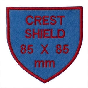 May include: Blue felt crest shield patch with red embroidered text that reads "CREST SHIELD 85 X 85 mm".