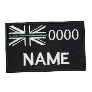 May include: Black embroidered patch with a white Union Jack flag, a green line, and the text "0000 NAME".