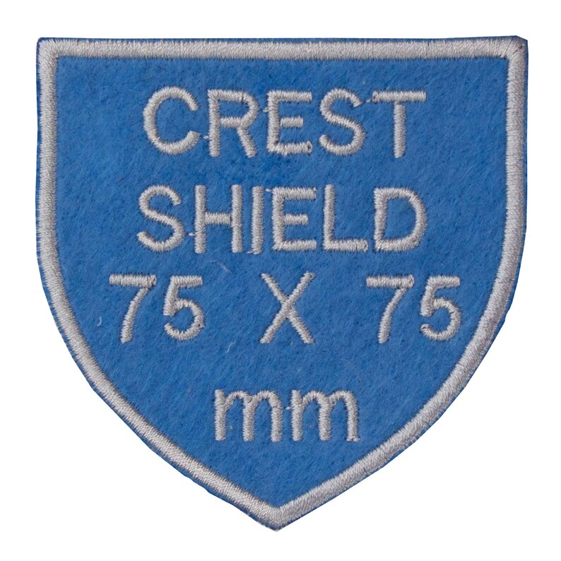 May include: A blue felt shield patch with white embroidered text that reads "CREST SHIELD 75 X 75 mm".