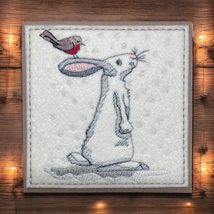 a* Une carte de voeux de Noël faite main. Broderie, lapin « De grands espoirs pour Noël »