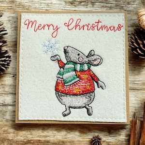 a* Une carte de Noël faite main. Frank the Mouse brodé offrant un flocon de neige de Noël magique au destinataire.