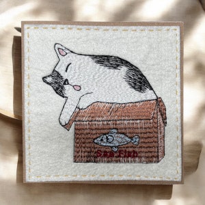 Notre carte de voeux faite main avec un chat brodé avec une boîte de poisson frais. « L'accroche parfaite » Idéal à encadrer et à conserver pour toujours.