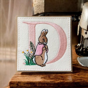 Personalisierte handgemachte Grußkarte mit gesticktem kleinen Hasen in rosa mit einem beliebigen Buchstaben des Alphabets. Neues Baby oder Geburtstag.