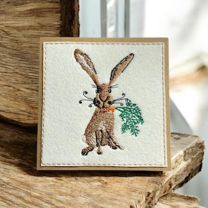 Liebevoll handgemachte Grußkarte mit einem handgestickten Wildkaninchen, das an einer Karotte knabbert. Perfekt zum Einrahmen und für immer aufbewahren. Nicht nur eine Karte.