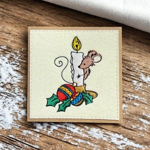 Une carte de Noël faite main avec des souris coquines. Broderie, . Souris effrontée grimpant à un chandelier.
