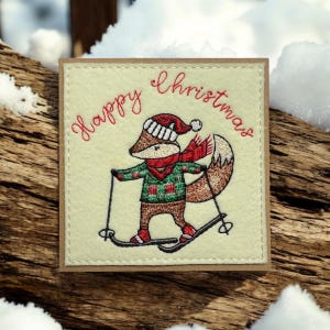 a* Une carte de Noël faite main. J'ai brodé Jacob le renard en train de tester son cadeau de Noël.