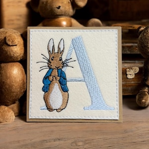 NEW FOR 2025 Handgemaakte wenskaart met geborduurd konijntje in een blauw jasje met een willekeurige letter van het alfabet. Nieuwe baby of verjaardag.