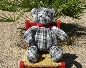 Könnte beinhalten: Ein schwarz-weiß karierter Teddybär mit einer roten Schleife sitzt auf einem roten Stuhl mit Korbgeflecht.