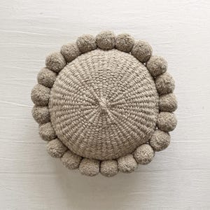 Cojín redondo con pompones de 12&quot; - ARENA