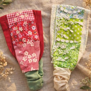 May include: Two fabric headbands with patchwork designs. One features red gingham, floral, and striped patterns. The other has green polka dots, floral fabric, and white lace trim. Both have gathered fabric at the base.