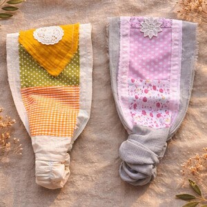 May include: Two fabric headbands with patchwork designs. One features yellow, green polka dots, and orange gingham. The other has pink polka dots and floral patterns, with a white lace flower accent.
