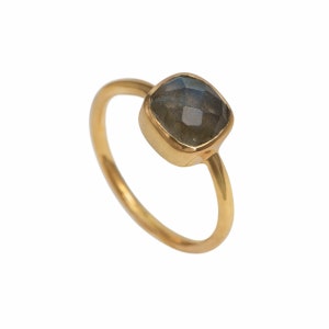 May include: A gold ring with a square-shaped, dark gray labradorite gemstone.