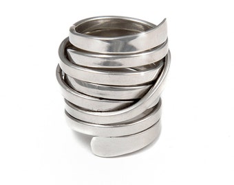 May include: A silver-colored ring with a unique spiral design. The ring is made of multiple bands of metal that wrap around each other, creating a layered effect. The ring has a smooth, polished finish and is set against a white background.