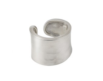 Puede incluir: Un anillo de plata con una banda ancha y plana que está ligeramente curvada. El anillo es liso y pulido.