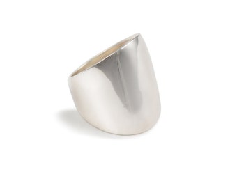 Puede incluir: Un anillo de plata con un diseño liso, redondeado y ligeramente curvado.