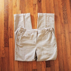 May include: A pair of beige corduroy trousers with a button fly and two front pockets.