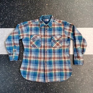 May include: A blue, green, brown, and white plaid flannel shirt with a button-up front and long sleeves.