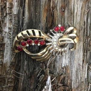 Broche arabesco dourado dos anos 1940 com strass vermelhos e brancos - presentes para madrinhas