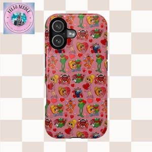 May include: Pink phone case featuring a repeating pattern of Muppet characters, hearts, and the words "I love you". The case has a dual-lens camera cutout and a logo in the upper left corner. The case is made of a durable material.