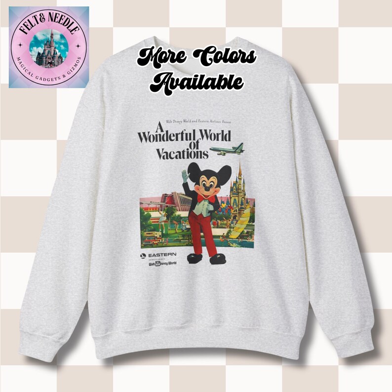 May include: A light gray sweatshirt featuring a graphic of Mickey Mouse in a vintage travel poster style. The poster reads "A Wonderful World of Vacations" with the text "More Colors Available" above the graphic. The sweatshirt has long sleeves.
