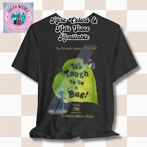 May include: A dark grey t-shirt with a green leaf design featuring a cartoon ant and the text "It's Tough to be a Bug!"  The text "Starring Flik and a cast of A Million Billion Bugs" is also included on the shirt.