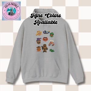 May include: Gray hooded sweatshirt with a graphic print of characters from the Muppets. The text "More Colors Available" is printed on the front of the sweatshirt.