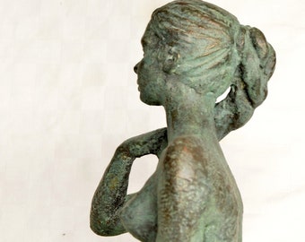 Statuette young woman seated on floor, with hand on shoulder,  green patina