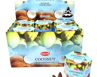 May include: A box of HEM Coconut Backflow Incense Cones. The box is blue and white with a picture of coconuts on it. There are two incense cones in the foreground.