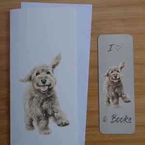 以下が含まれることがあります： 笑顔の茶色の犬のイラストが描かれたグリーティングカードとブックマークのセット。カードは白で、ブックマークはグレーで「I ♡ & Books」の文字が入っています。