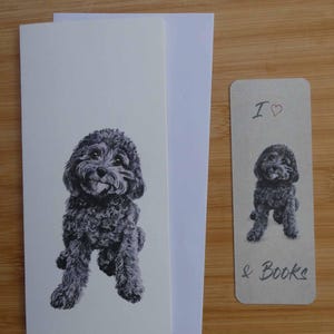 以下が含まれることがあります： ふわふわした犬の白黒イラストが描かれたグリーティングカードとブックマークのセットです。ブックマークには「I ♡ & Books」と書かれています。カードにはお揃いの封筒が付いています。