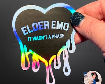 May include: A holographic sticker in the shape of a dripping heart with the text "Elder Emo It Wasn't A Phase" in white lettering.