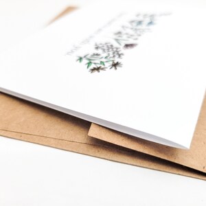 May include: A white card with a floral design and the text "Thank you for everything" printed on it. The card is folded in half and is sitting on top of a brown envelope.