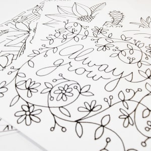 May include: Black and white line art print featuring the words "always grow" surrounded by floral designs.