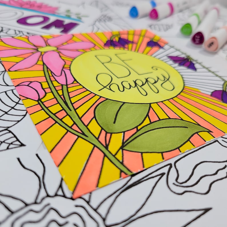 May include: A yellow sun with orange rays and a pink flower with green leaves. The sun has the words "BE happy" written in black inside it.