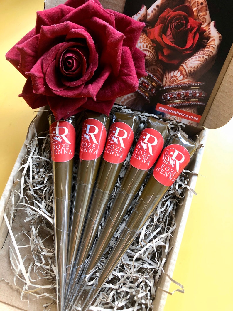 May include: Five brown henna cones with red labels that say "Roze Henna" in a box with shredded paper and a red rose.