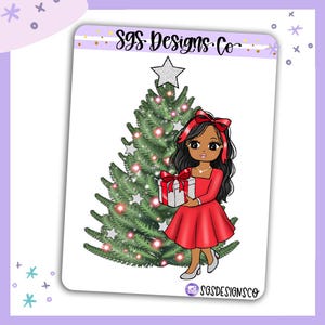 Puede incluir: Una hoja de pegatinas con un personaje de dibujos animados de pelo largo y oscuro, con vestido rojo y lazo rojo, sosteniendo un regalo plateado. Detrás hay un árbol de Navidad verde decorado con estrellas plateadas y luces rosas. El texto SGS Designs Co aparece arriba y abajo.